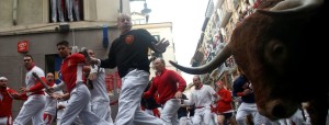 Runners sprint along Nunez del Cuvillo bulls during the seventh running of the bulls at the San Fermin festival in Pamplona